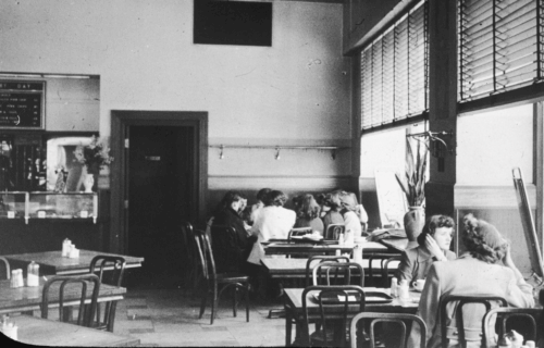 The interior of a restaurant with mostly women sitting at tables near windows.
