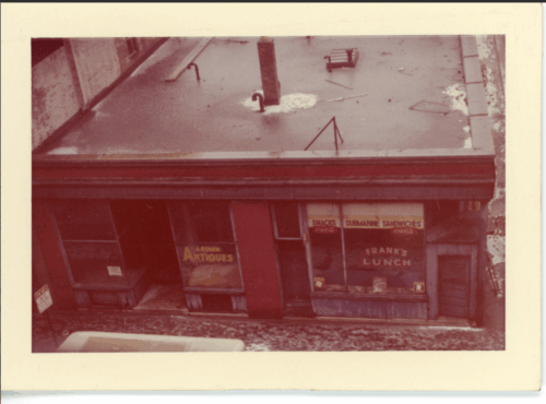 A sepia image of a building from above with two storefront.