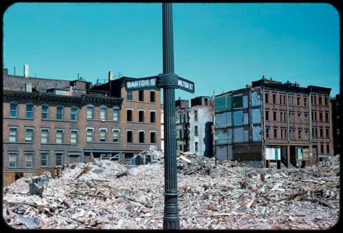 A photo of a street lamp in front of a pile of rubble.