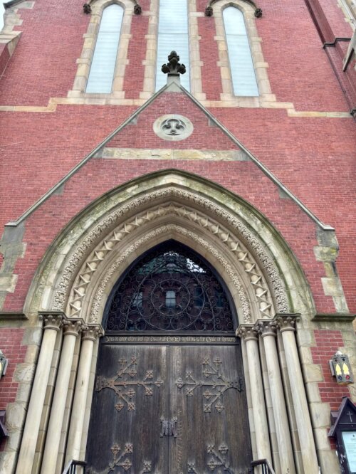 A church portal door with Gothic style elements.