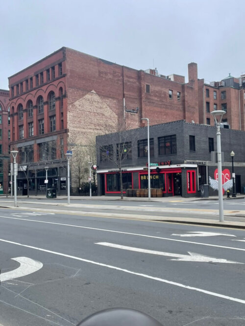 Two brick buildings. The taller one is four stories tall and the shorter one is two stories and painted grey.