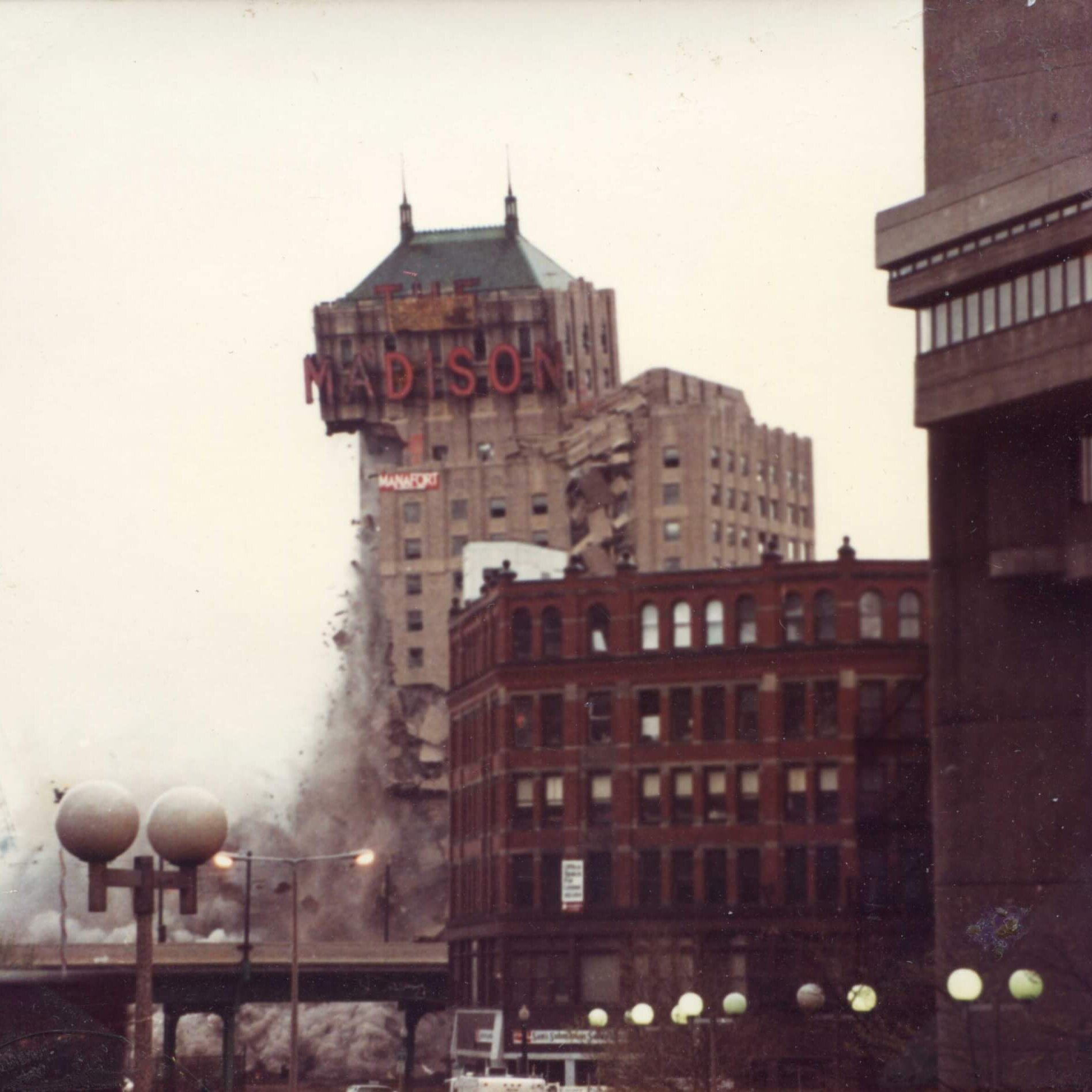 A tall hotel with the marquee that says Madison. The left side is gone and the marquee is starting to fall.