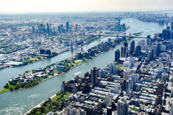An aerial view of New York City including Roosevelt Island in between Queens and Manhattan.