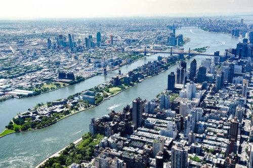 An aerial view of New York City including Roosevelt Island in between Queens and Manhattan.