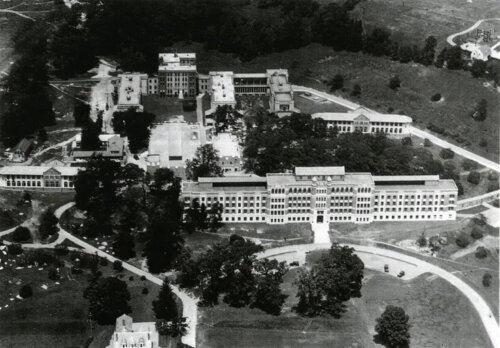 An aerial shot of a large building complex with a central courtyard and many windows.
