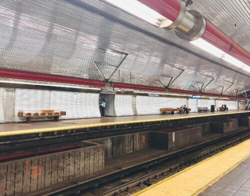 A subway station with a central track area. The stop is decorated with red.