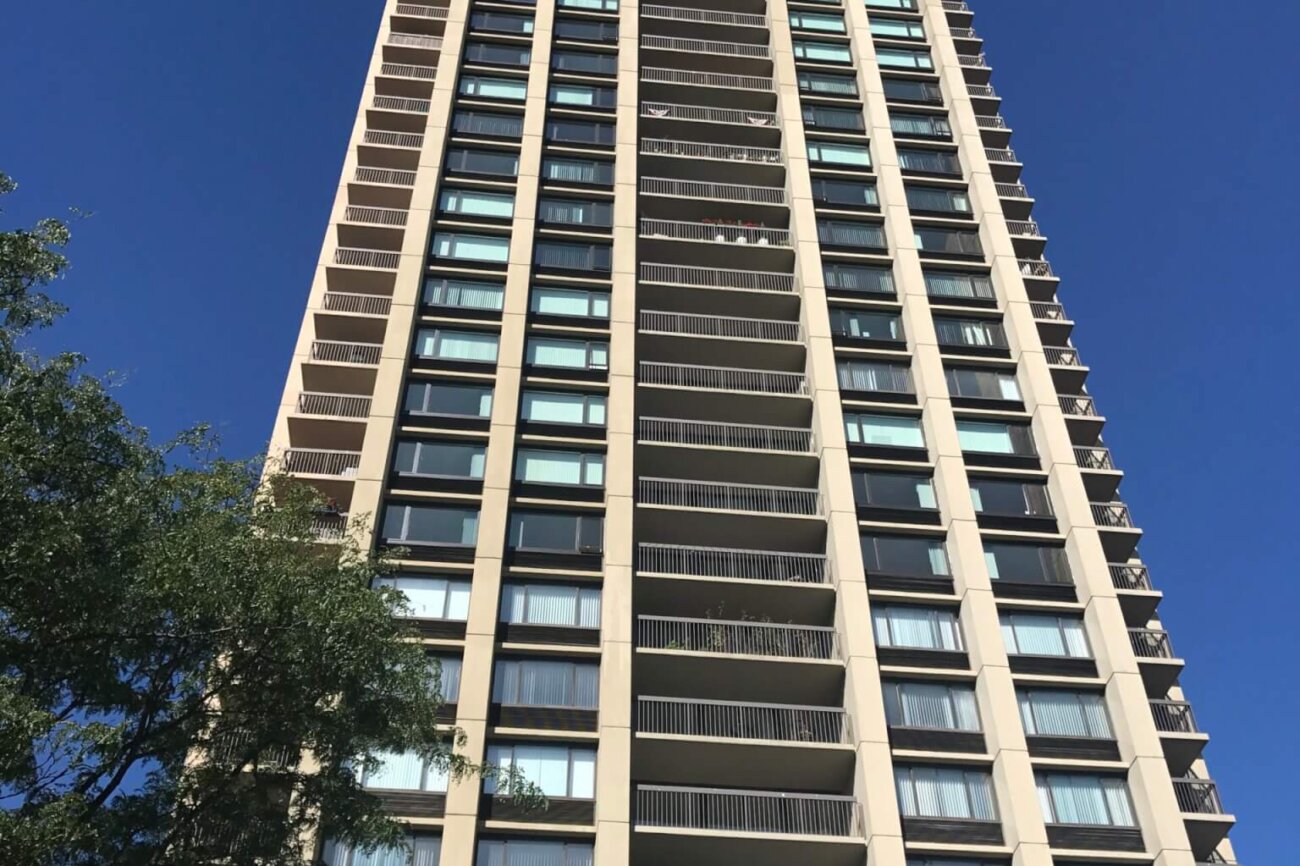 A tall residential tower from the ground looking up.