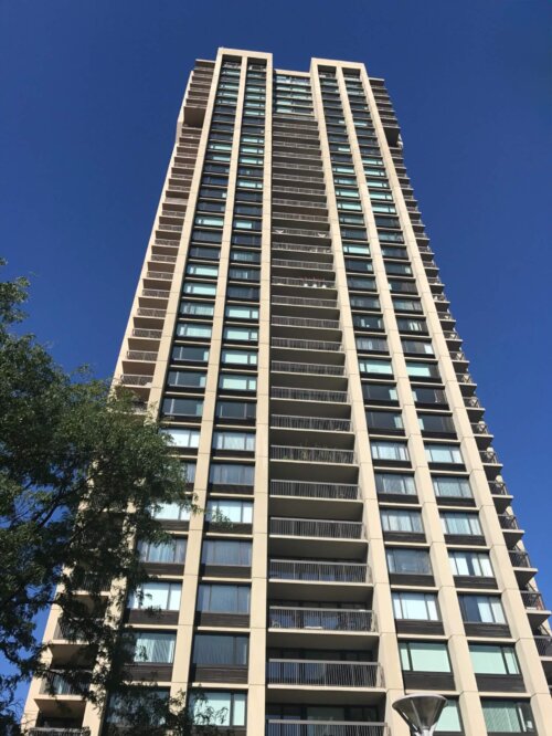 A tall residential tower from the ground looking up.