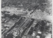 An aerial view of a neighborhood with a large train terminal at the bottom left. There is a gash through the area as buildings have been torn down for a highway construction.