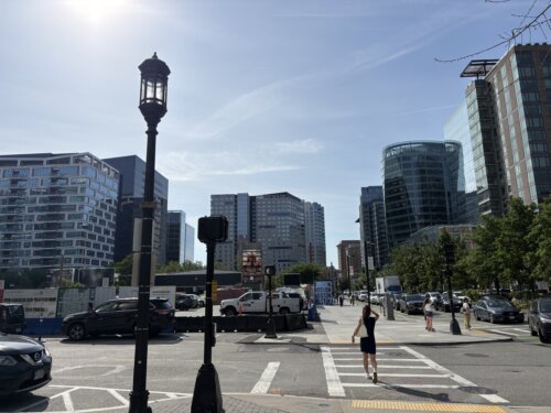 A street corner surrounded by blocks of tall glass buildings.