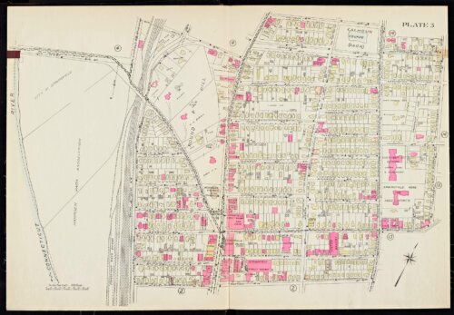 An atlas page showing a river on the left side of the page with train tracks running through a neighborhood.