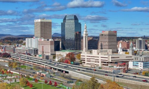 A city skyline with a large highway in the foreground.
