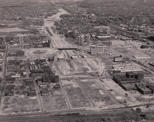 An area of cleared land in between two sides of a city. Many buildings are missing on several blocks.