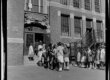 A group of elementary students wait to enter a school building.