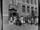 A group of elementary students wait to enter a school building.
