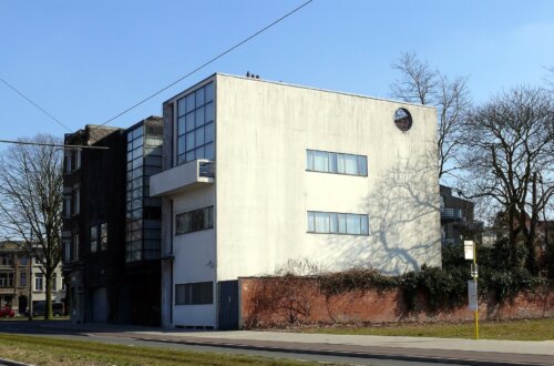 A three story concrete building with long horizontal windows on the side facing the camera.