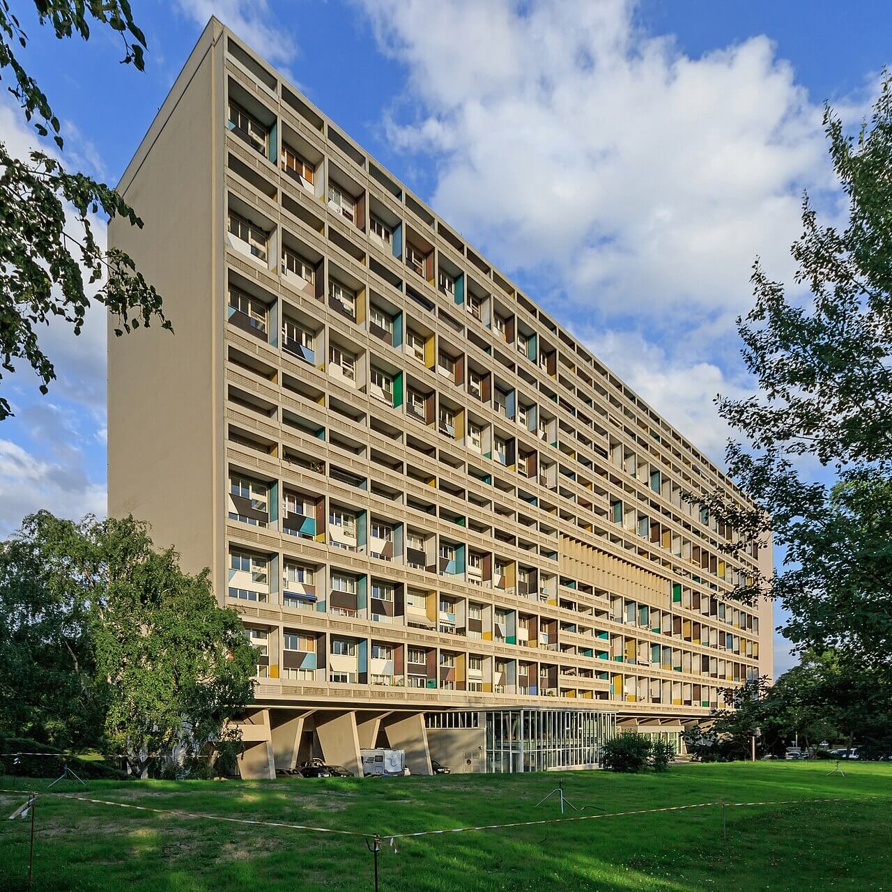 A large square apartment building with balconies on the long side. The balconies are colorfully painted.