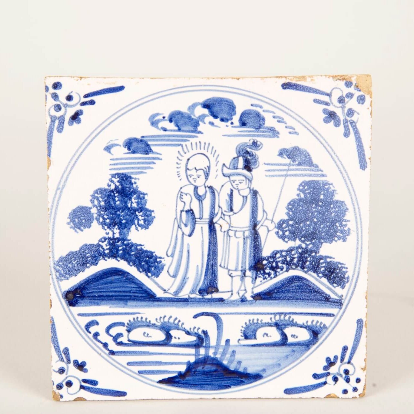 A white and blue tile with a couple standing in front of a stream.
