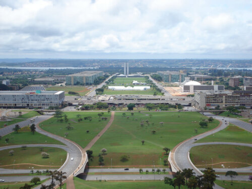 A view of a monumental axis of a capital city. There is parkland between each of the large buildings.