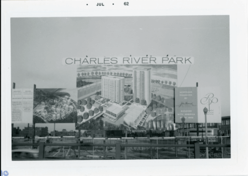 A photo of a sign for a residential development labeled Charles River Park with an empty lot in the background.
