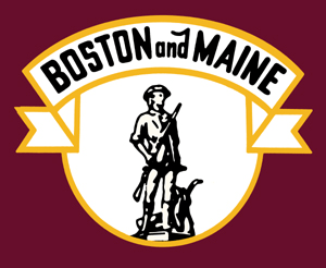 A brown background with a shield of white with a banner on top. The shield has a minute man holding a gun.