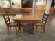 An image of a brown enamel top table surrounding by three chairs.