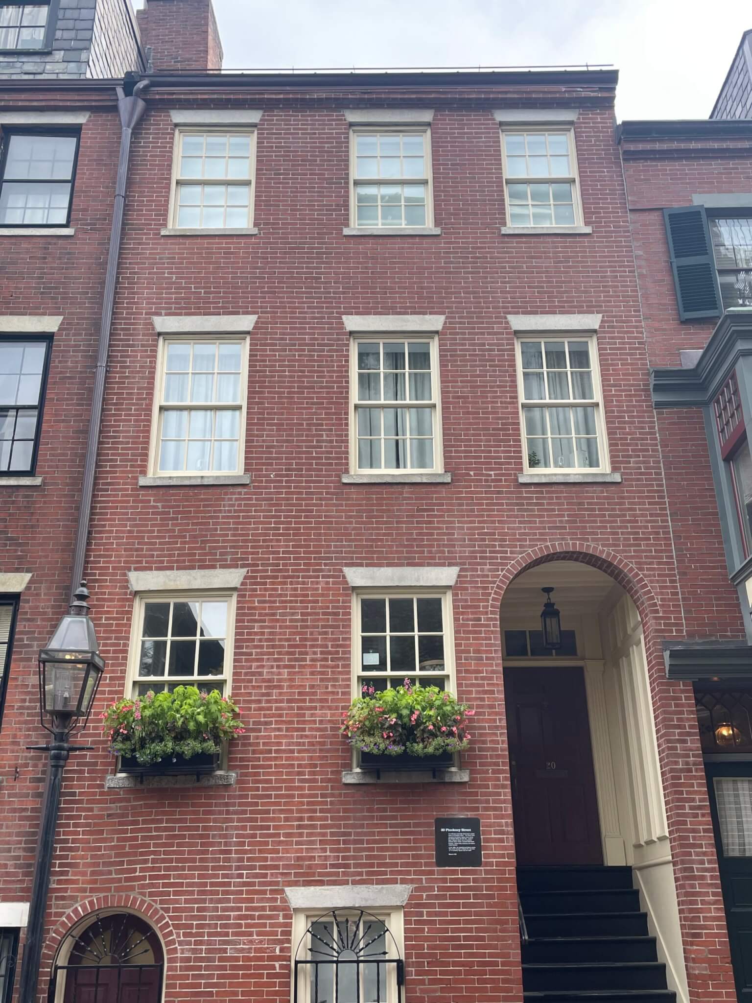 An image of a four story brick apartment building with an arched doorway.