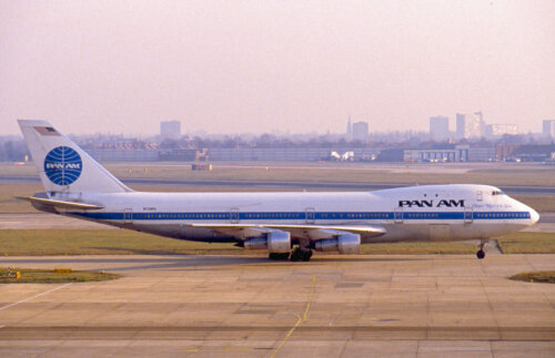 A plane on the tarmac of an airport in a sunset.