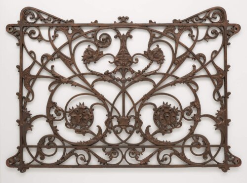 An image of a decorative cast iron railing piece with floral designs.