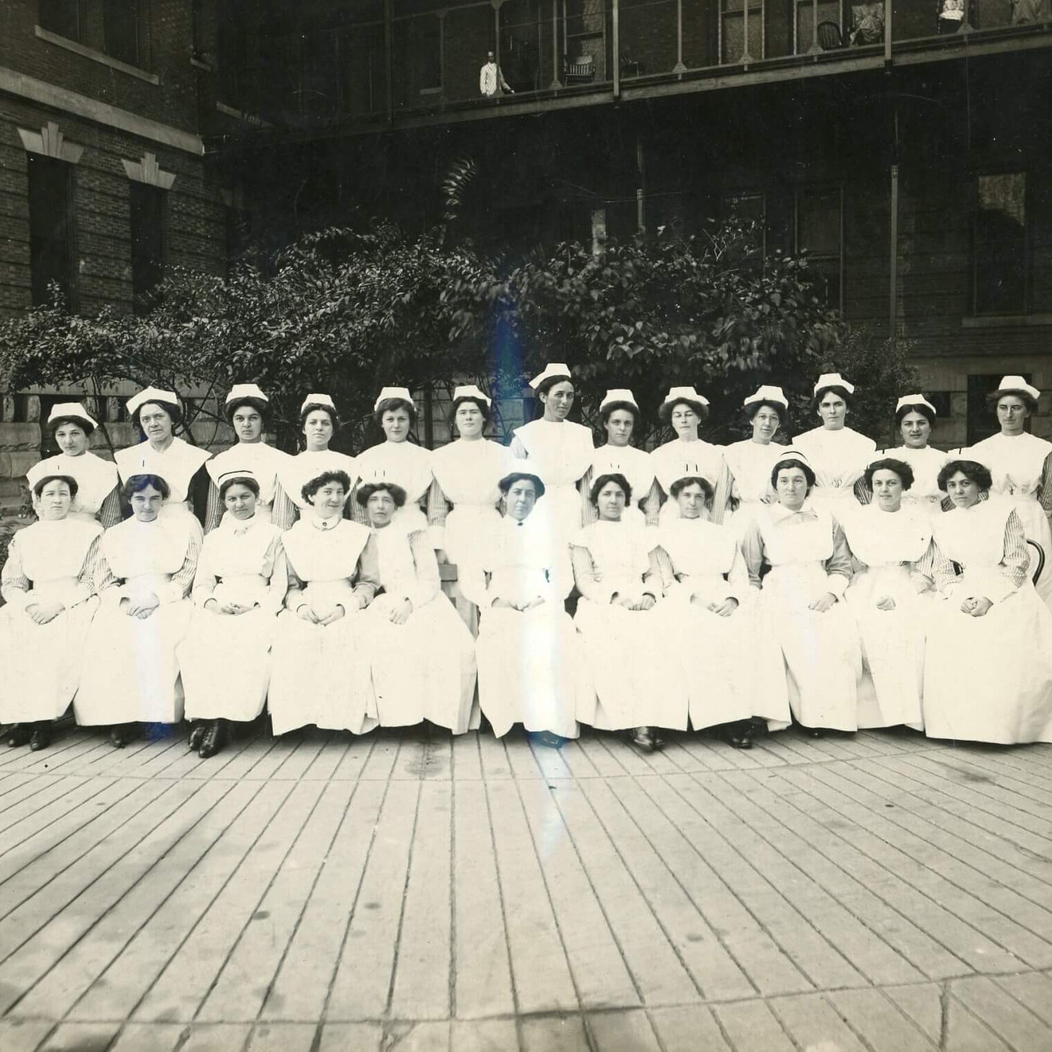 Two rows of women in nurses uniforms posing for a portrait.